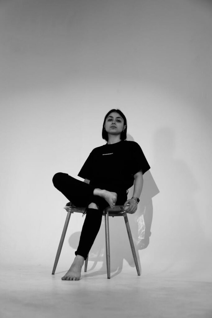 A woman sitting on a chair in a black and white photo